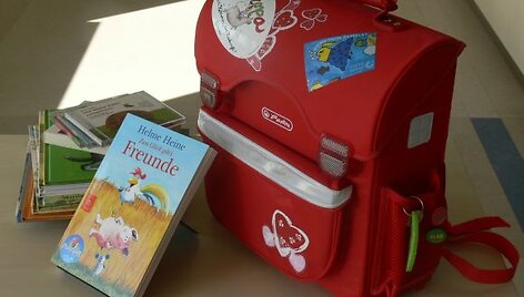 Voki&scaron;kų knygelių ir kitų priemonių pilna kuprinė.