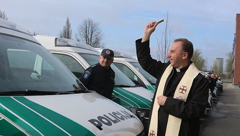 Kunigas Vilius Viktoravičius šventina naujus policijos automobilius.