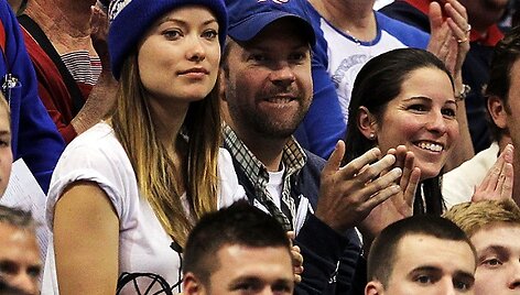 Mėlynomis kepuraitėmis pasipuo&scaron;ę Jasonas Sudeikis ir Olivia Wild stebi krep&scaron;inio rungtynes.