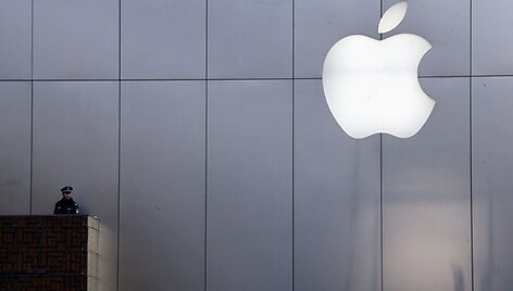 Policininkas i&scaron; balkono stebi prie &bdquo;Apple&ldquo; parduotuvės susirinkusius žmones.