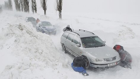 Vyrai deda ant automobilių padangų grandines.