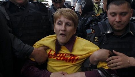 Policininkai veda sulaikytą opozicijos aktyvistę.