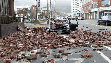 Vėjo ir stiprios liūties neatlaikiusi dalis sienos nugriuvo ant automobilio.