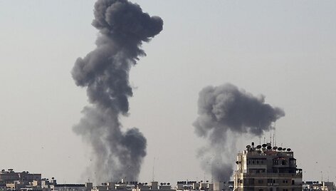 Po raketų sprogimų kyla dūmai vir&scaron; Gazos miesto