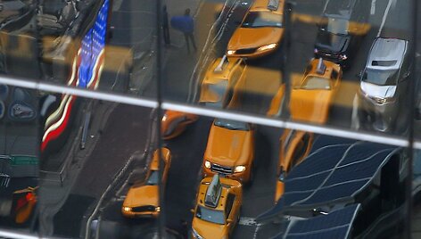 Taksi automobiliai atsispindi Niujorko pastato lange