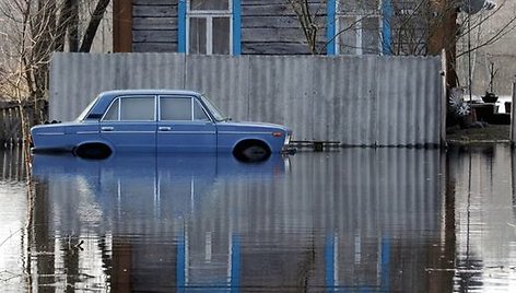 Šalia namo stovi apsemtas automobilis