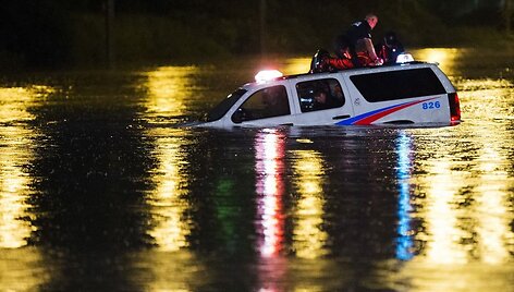 Policininkas ant savo apsemto automobilio stogo