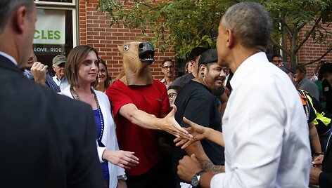 JAV prezidentas Barackas Obama sveikinasi su vyru, dėvinčiu arklio galvos kaukę.
