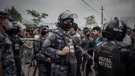 Katmandu policija prižiūri autobusų laukiančias minias žmonių.