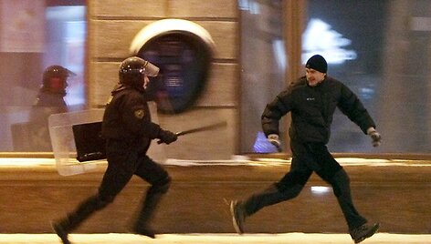 Protestuotojas bėga nuo pareigūno