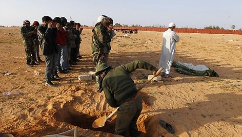 Libijos sukilėliai kasa duobę palaidoti žmogui, kurį rado automobilyje netoli Ras al Unafo.