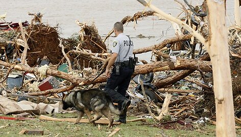 Policininkas su &scaron;unimi ie&scaron;ko per tornadą dingusių žmonių.