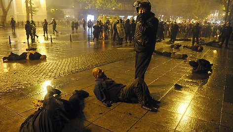 Ant grindinio guli policijos sulaikyti protestuotojai.