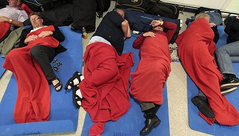 Prie savo lagaminų miegantys keliautojai Edinburgo oro uoste