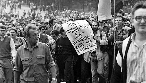 Žmonės žygiuoja link Rusijos Baltųjų rūmų ir ne&scaron;a plakatą su užra&scaron;u &bdquo;Ne fa&scaron;izmui! Taip Jelcinui! Visi į streiką!&ldquo; (1991 m. rugpjūčio 19 d.).
