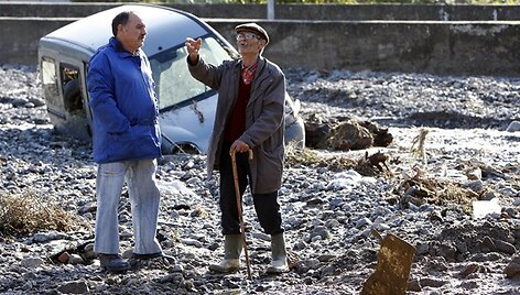 Vyrai kalbasi netoli purvo nuo&scaron;liaužos nuniokoto automobilio.