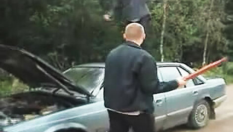 Vyrai niokoja automobilį.