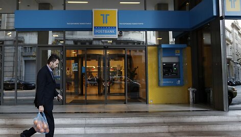 Žmogus eina pro &bdquo;Hellenic Postbank&ldquo; banką Atėnuose