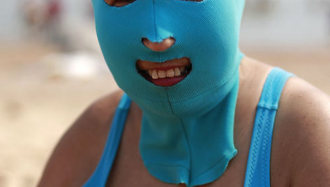 Savo veidą saugančios kinės paplūdimiuose mūvi nailonines kaukes