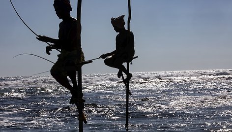 Ant stiebų sėdintys netikri žvejai už pinigus pozuojantys turistams