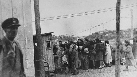 Grupė žydų grįžta į getą po dienos priverstinio darbo lauke. Išsirikiavusius eilėje juos apieško vokiečių ir lietuvių sargybiniai