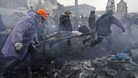 Anti-government protesters carry an injured man on a stretcher after clashes with riot police in the Independence Square in Kiev February 20, 2014. Ukrainian protesters hurling petrol bombs and paving stones drove riot police from the central square in Kiev on Thursday despite a "truce" which embatt