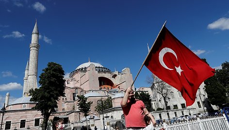 Vyras prie Hagia Sophia vilkioja Turkijos vėliavą. / MURAD SEZER / REUTERS