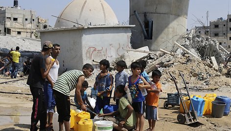 Palestiniečių vaikai renka vandenį per penkių dienų paliaubas Gazos juostoje. / Ibraheem Abu Mustafa / REUTERS