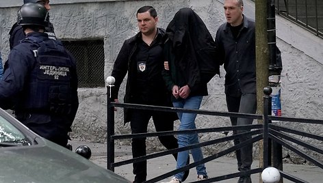 Serbų policijos pareigūnai palydi įtariamąjį / OLIVER BUNIC / AFP