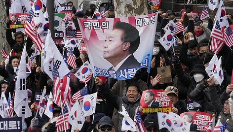 Yoon Suk-yeolo rėmėjai i&scaron;kėlę plakatą su jo atvaizdu / Ahn Young-joon / AP