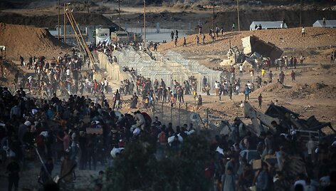 Palestiniečiai eina į humanitarinės pagalbos skirstymo punktus / EYAD BABA / AFP