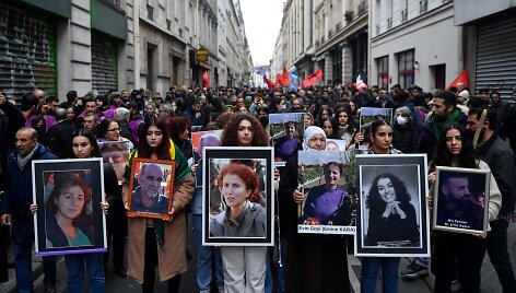 Demonstrantai ne&scaron;a Paryžiuje nužudytų kurdų portretus.