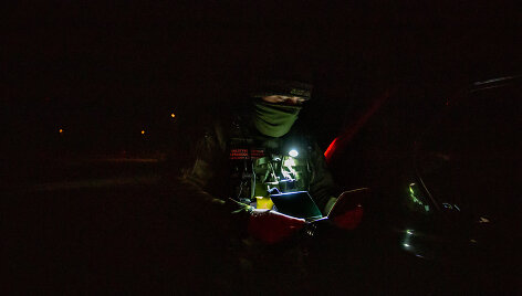 Valstybės sienos apsaugos tarnybos pareigūnas Latežerio kaime (Druskininkų sav.)  tikrina dokumentus įvažiuojant į nepaprastosios padėties zoną pasienyje 