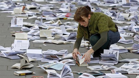 Moteris išdėlioja knygas renginiui skirtam pasaulinei knygos ir autorinių teisių dienai Bukarešte