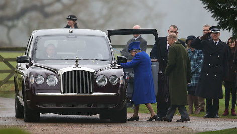 Karalienė Elizabeth II ir princas Philipas lipa į automobilį.