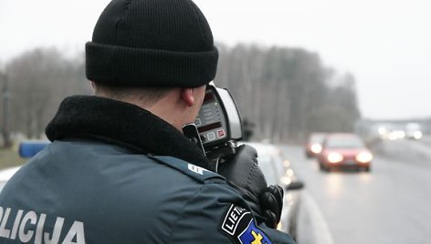 Greitį matuojantis policininkas.