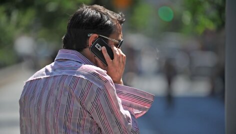 Žmogus &scaron;neka mobiliuoju telefonu