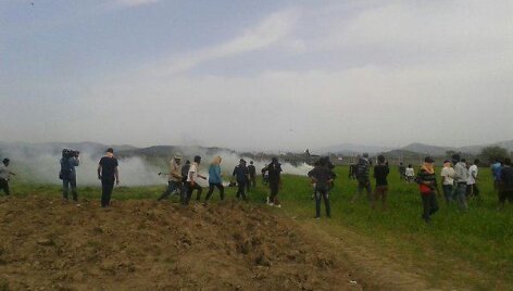 Makedonijos policija a&scaron;arinėmis dujomis vaikė migrantus prie sienos su Graikija