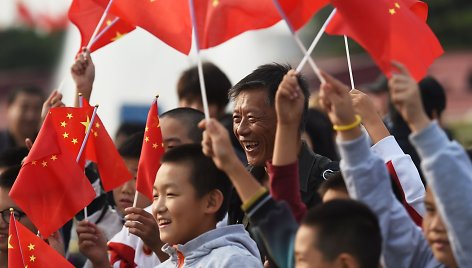 Kinai mojuoja vėliavomis nacionalinės dienos proga Pekine