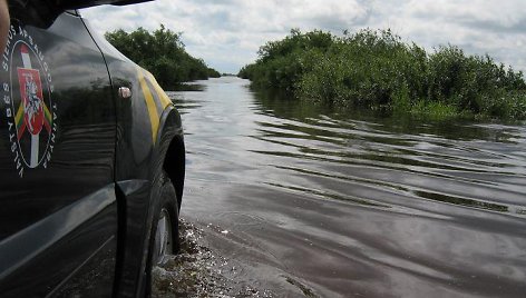 Asociatyvinė iliustracija: pasieniečių visureigis prie užlieto kelio