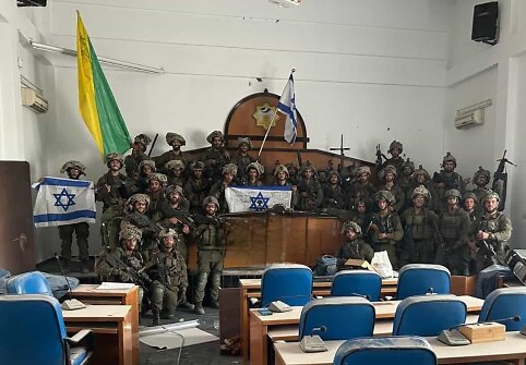 Izraelio pajėgų Golani brigados kariai pozuoja nuotraukai užimtame parlamento pastate Gazos mieste
