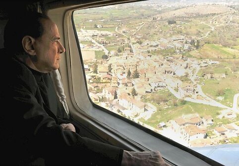 Ministras pirmininkas Silvio Berlusconi stebi žemės drebėjimo padarinius.