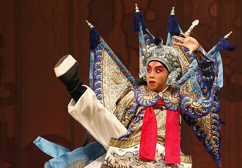 Kinų opera sujungia pasakojimą, muziką, kostiumus, grimą ir akrobatiką.