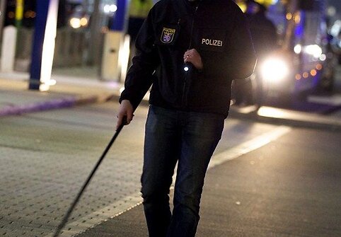 Policininkas su metalo detektoriumi