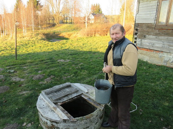 Photo of A.Grygelaitis / Alvydas Savickas drinking water from the village of Duonelaičiai from the well of his own yard