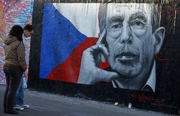 „Reuters“/„Scanpix“ nuotr./Žmonės prie graffiti piešinio skirto pagerbti Čekijos prezidentą Vaclava Havela.