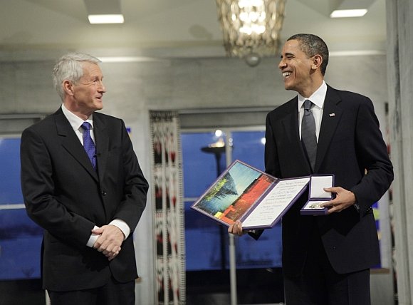 AFP/„Scanpix“ nuotr./Barackas Obama atsiėmė Nobelio taikos premiją iš Norvegijos Nobelio komiteto komiteto pirmininko Thorbjoerno Jaglando rankų.