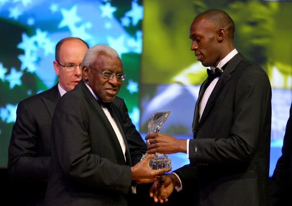AFP/„Scanpix“ nuotr./IAAF prezidentas Lamine Diackas apdovanoja Usainą Boltą
