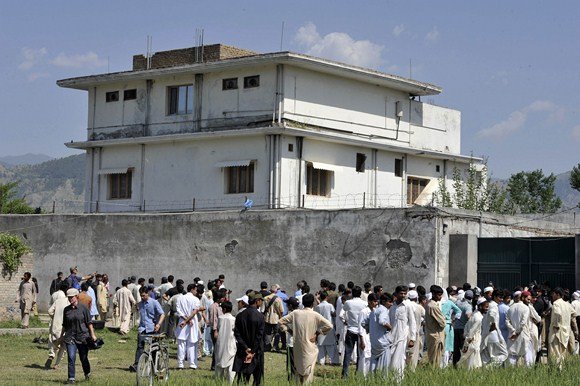 AFP/„Scanpix“ nuotr./Vietos gyventojai ir žurnalistai šalia stovyklos, kurioje buvo nukautas Osama bin Ladenas