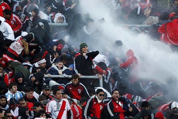 „Reuters“/„Scanpix“ nuotr./Vandens srove bandoma sutramdyti įsisiautėjusius „River Plate“ gerbėjus